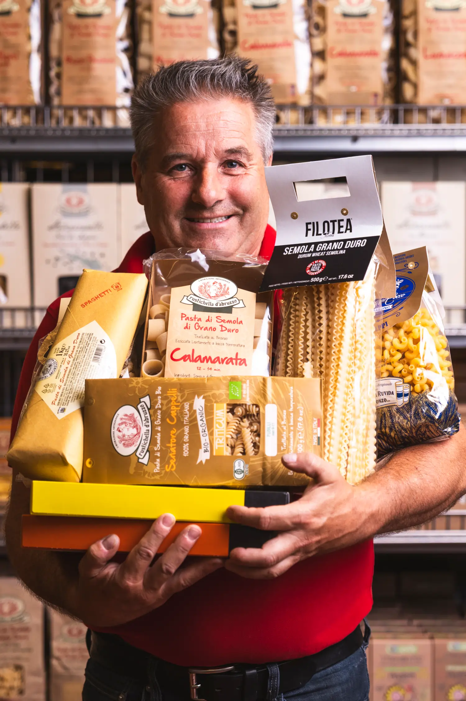 Ein Mitarbeiter des Hofer Market hält verschiedene Pasta-Waren.